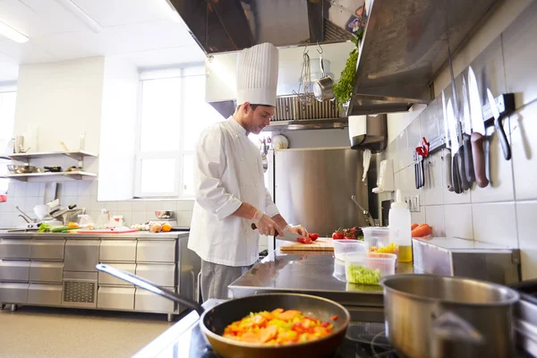 Male chef cooking food at restaurant kitchen — Stock Photo, Image