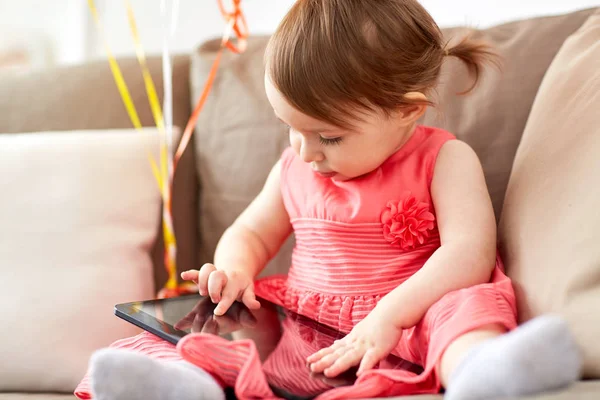 Evde koltukta oturan tablet pc ile kız bebek — Stok fotoğraf