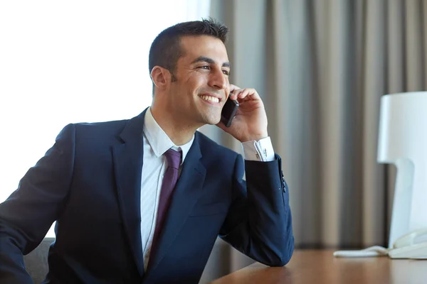 Empresário chamando no smartphone no quarto de hotel — Fotografia de Stock