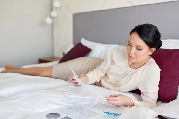 Geschäftsfrau mit Papieren arbeitet im Hotelzimmer — Stockfoto