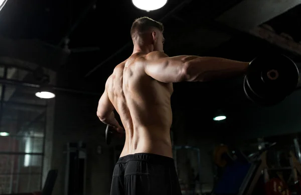 Primer plano del hombre con pesas haciendo ejercicio en el gimnasio — Foto de Stock