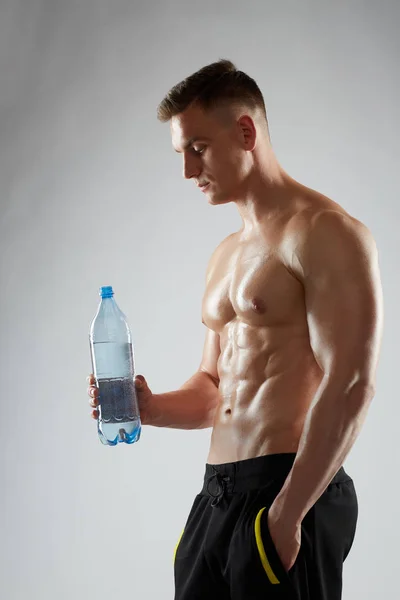 Mladý muž nebo kulturista s lahví vody — Stock fotografie