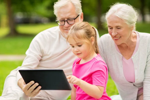 Grootouders en kleindochter met tablet pc — Stockfoto