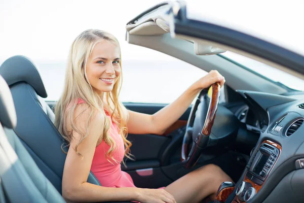 Happy young woman driving convertible car — Stock Photo, Image