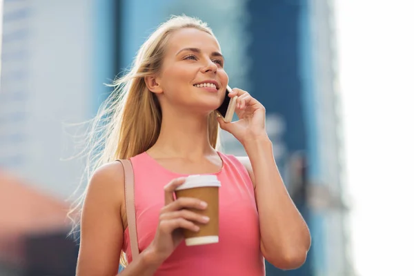 Woman with coffee calling on smartphone in city — Stock Photo, Image