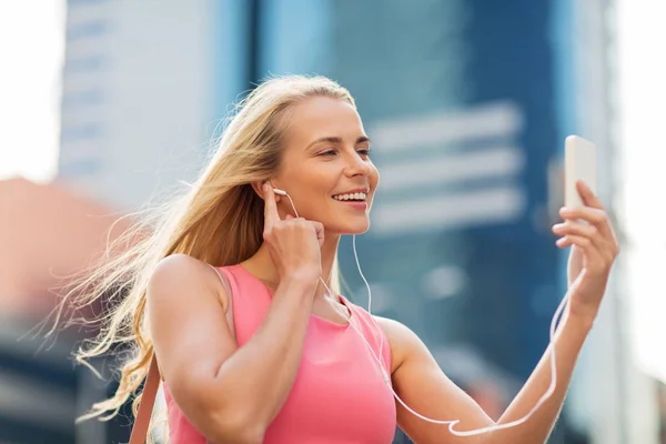 Jeune femme heureuse avec smartphone et écouteurs — Photo