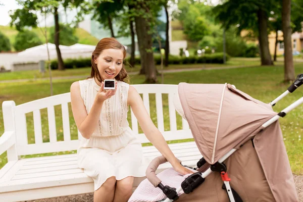 Mutter mit Kinderwagen und Smartphone im Sommerpark — Stockfoto