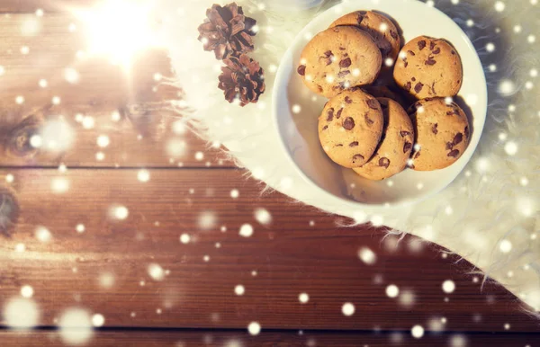 Zavření souborů cookie v misce a šišky na kožešinové předložce — Stock fotografie