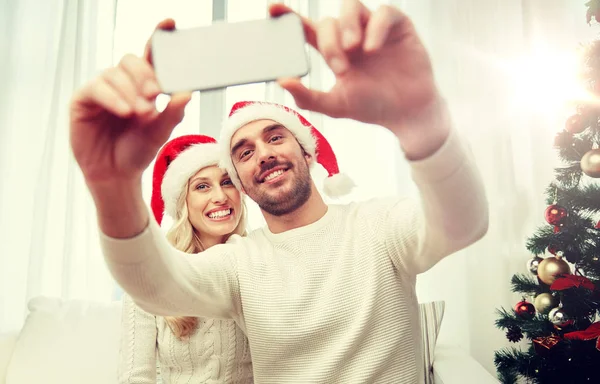 Пара делает селфи со смартфоном на Рождество — стоковое фото