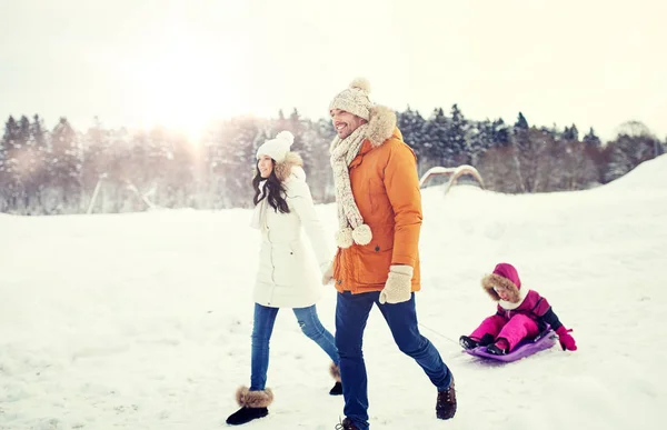 Família feliz com trenó andando no inverno ao ar livre — Fotografia de Stock