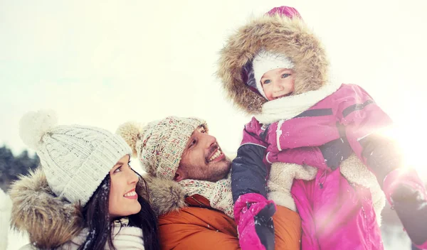 Счастливая семья с ребенком в зимней одежде на открытом воздухе — стоковое фото