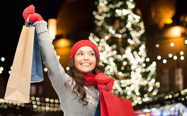 Femme heureuse avec des sacs à provisions sur l'arbre de Noël — Photo