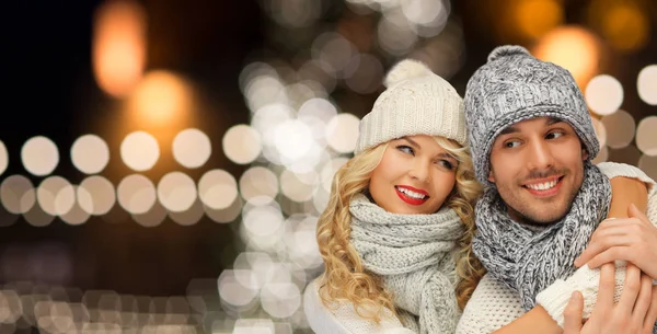 Feliz pareja abrazándose a través de luces de Navidad — Foto de Stock