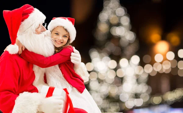 Jultomte med glad tjej över julgran — Stockfoto
