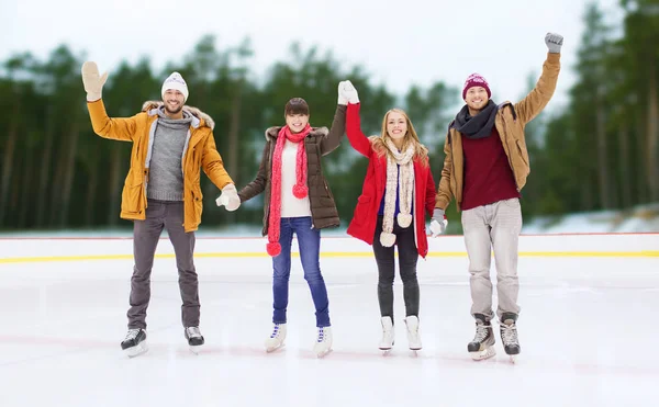 Happy friends waving hands on outdoor skating rink — Stock Photo, Image