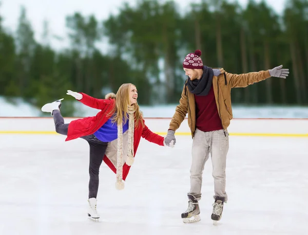 Feliz casal de mãos dadas na pista de patinação — Fotografia de Stock