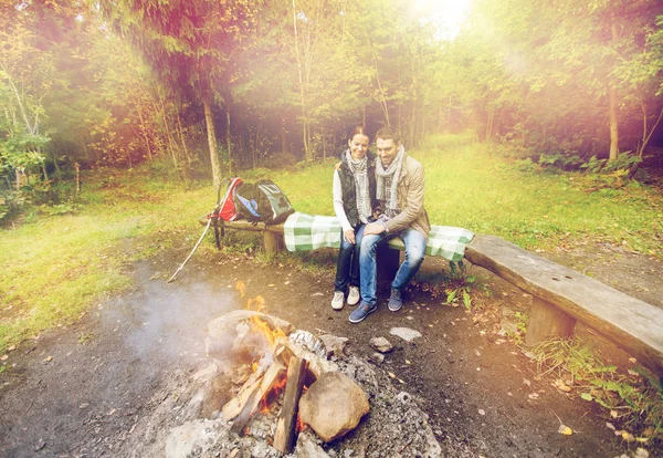 Ευτυχισμένο ζευγάρι που κάθεται σε παγκάκι κοντά άναμα φωτιάς — Φωτογραφία Αρχείου