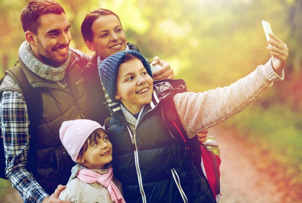 Family taking selfie with smartphone in woods — Stock Photo, Image