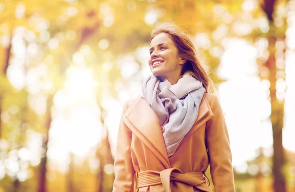 Schöne glückliche junge Frau, die im herbstlichen Park spaziert — Stockfoto