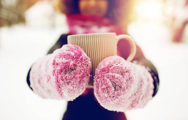 Закрываем глаза на женщину с чайной кружкой на улице зимой — стоковое фото