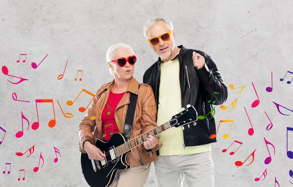Coppia anziana in occhiali da sole con chitarra elettrica — Foto Stock