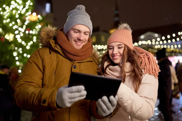 Feliz pareja con PC tableta en el mercado de Navidad —  Fotos de Stock