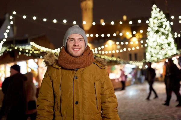 Szczęśliwy młody człowiek o Jarmark bożonarodzeniowy w zimie — Zdjęcie stockowe