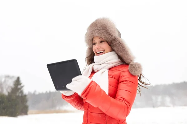 Женщина в зимней меховой шляпе с планшетным ПК на открытом воздухе — стоковое фото