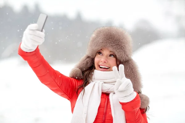 Gelukkige vrouw die selfie buiten in de winter — Stockfoto