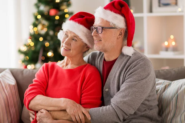 Happy senior couple in santa hats at christmas — Stock Photo, Image