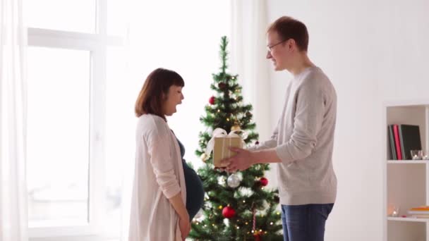 Marido dando regalo de Navidad a la esposa embarazada — Vídeo de stock