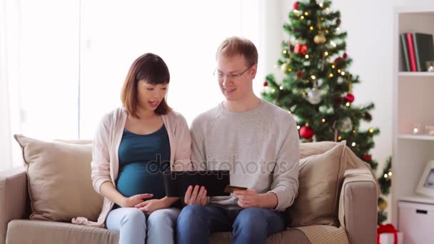 Mężczyzna i żona w ciąży, zakupy online, na Boże Narodzenie — Wideo stockowe