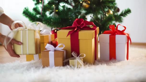 Mains mettre des boîtes-cadeaux sous l'arbre de Noël — Video