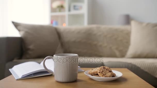 Galletas de avena de chocolate y taza con bebida caliente — Vídeos de Stock