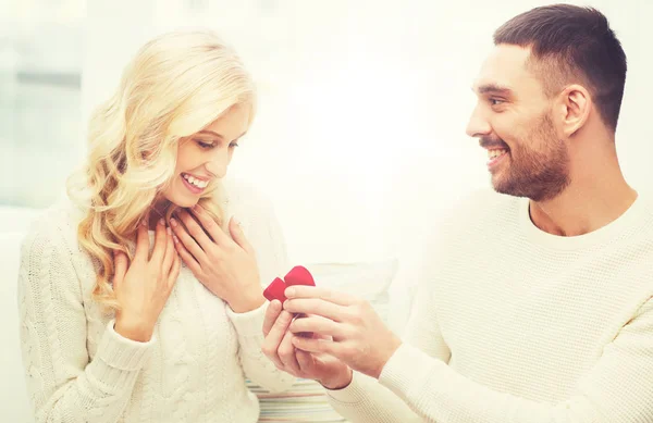 Hombre feliz dando anillo de compromiso a la mujer en casa — Foto de Stock