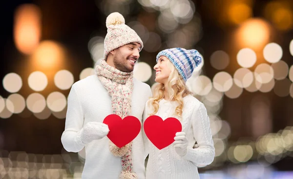 Casal com corações vermelhos sobre luzes de Natal — Fotografia de Stock