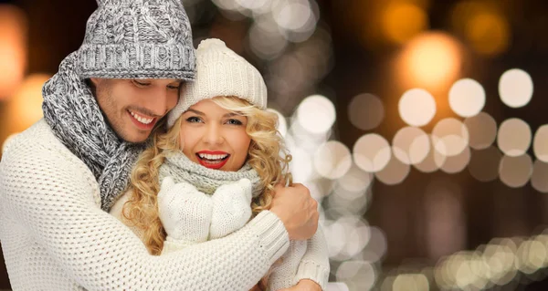 Feliz pareja abrazándose a través de luces de Navidad — Foto de Stock