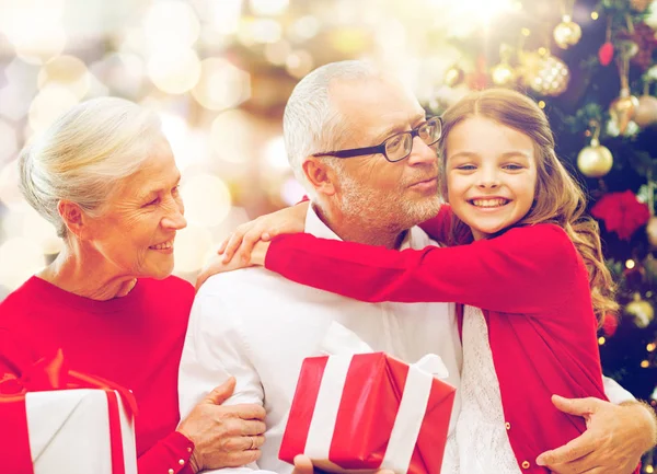 Happy family with christmas gifts over lights — Stock Photo, Image