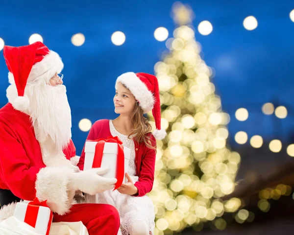 Santa claus and happy girl with christmas gift — Stock Photo, Image