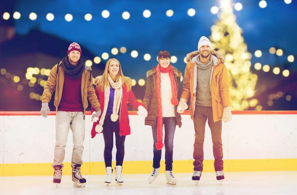 Happy friends on christmas skating rink — Stock Photo, Image