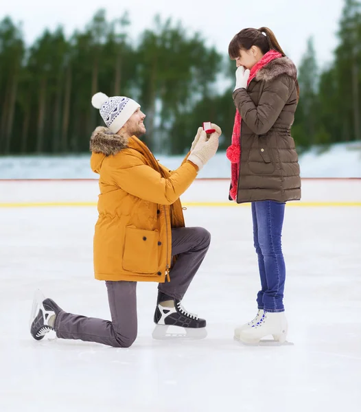 Glückliches Paar mit Verlobungsring auf Eisbahn — Stockfoto