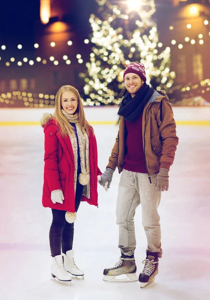 Glückliches Paar hält Händchen auf Eisbahn — Stockfoto