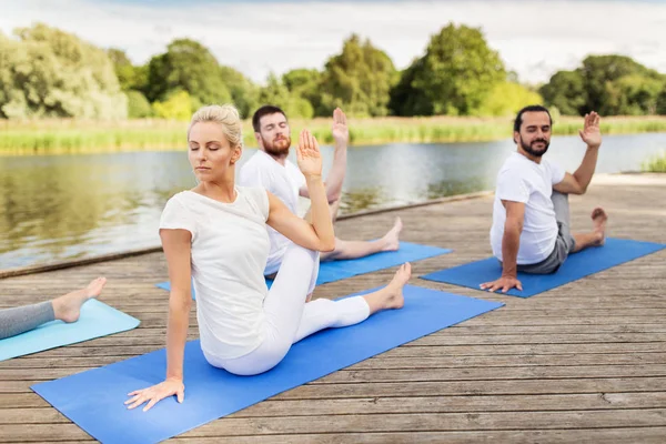 Människor gör yoga i halva Sagan om fiskarna pose — Stockfoto