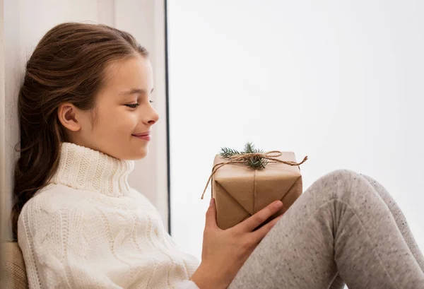 Menina com presente de Natal sentado em casa — Fotografia de Stock