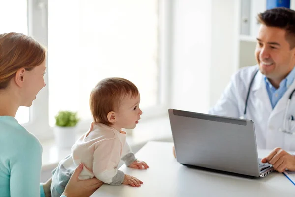 Mulher com bebê e médico com laptop na clínica — Fotografia de Stock