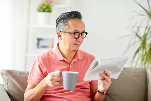 Homem bebendo café e lendo jornal em casa — Fotografia de Stock