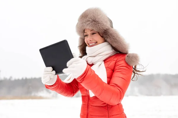 Vrouw in winter bont muts met tablet pc buitenshuis — Stockfoto