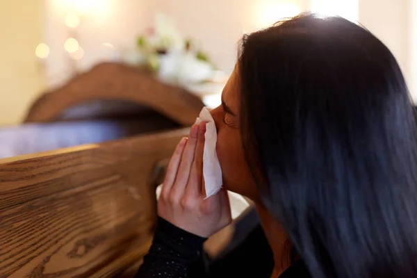 Mujer con ataúd llorando en el funeral en la iglesia — Foto de Stock
