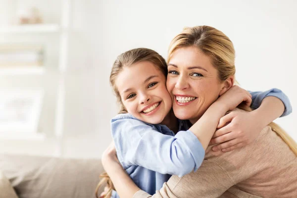 Feliz familia sonriente abrazándose en el sofá en casa —  Fotos de Stock