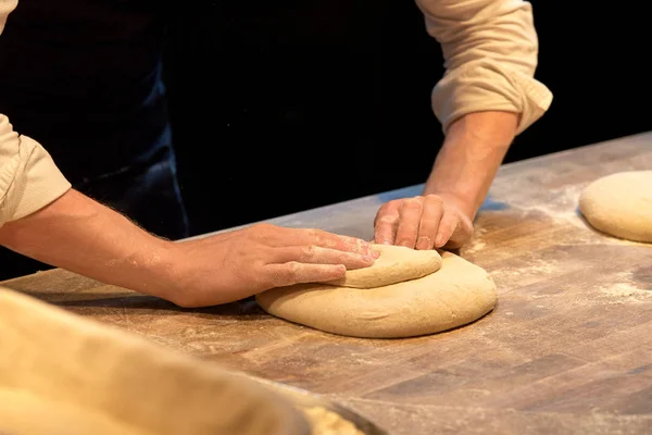 Шеф-повар или пекарь готовит тесто в пекарне — стоковое фото